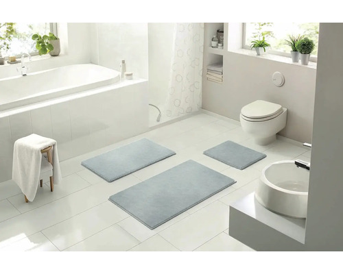 Koupelna s vanou, toaletou, umyvadlem a sadou koupelnových koberců