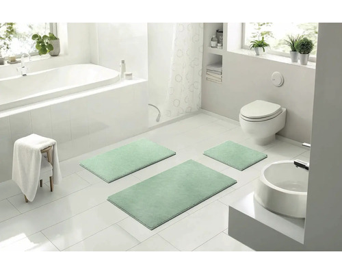 Moderní koupelna s vanou, toaletou, umyvadlem a sadou 3dílných koupelnových předložek.