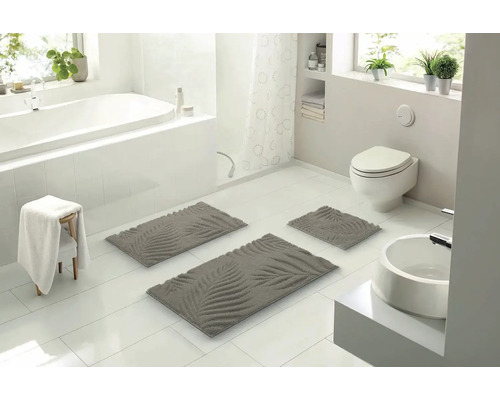 Koupelna s vanou, toaletou, umyvadlem a sadou koupelnových předložek s rostlinným vzorem