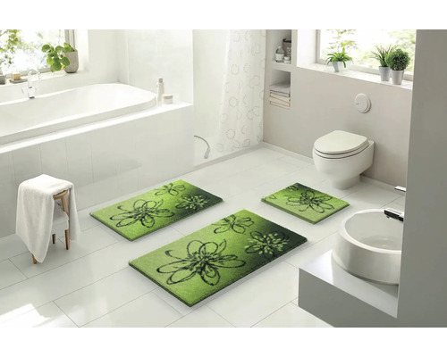 Koupelna s vanou, toaletou, umyvadlem a koupelnovými předložkami s květinovým vzorem