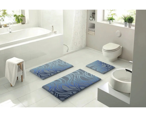 Koupelna s vanou, toaletou, umyvadlem a sadou tří koupelnových koberečků s modrým vzorem