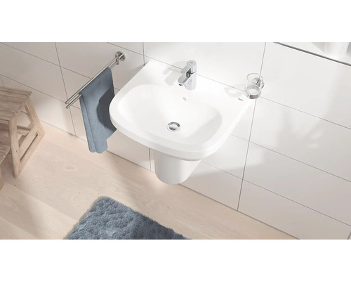 Moderní koupelna s bílým umyvadlem, vodovodní baterií a držákem na ručníky.