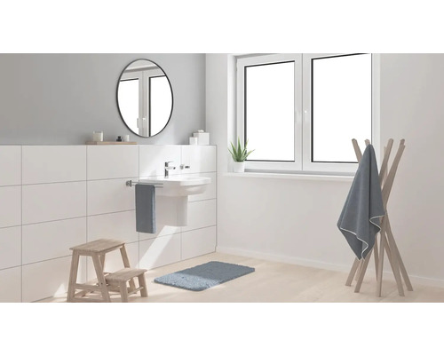 Světlá koupelna s umyvadlem, zrcadlem, oknem a držákem na ručníky