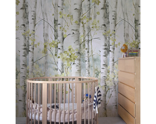 Dětský pokoj s tapetou s motivem břízy, kulatou dětskou postýlkou a komodou