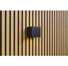 Nástěnné svítidlo ve tvaru krychle na dřevěné obkladové stěně