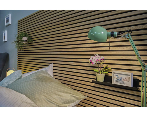 Ložnice s postelí, stěnovými panely a zelenou lampou