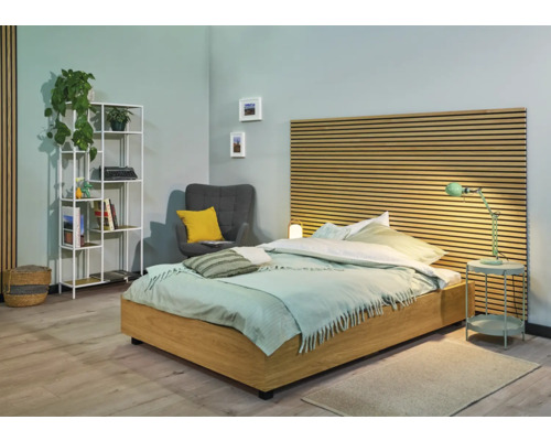 Světlá ložnice s postelí, nočním stolkem, regálem a křeslem