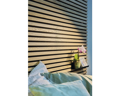 Ložnice s dřevěnými stěnovými panely a policí s dekorací