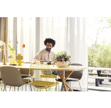 Světlá jídelna s jídelním stolem, židlemi a osobou, která píše