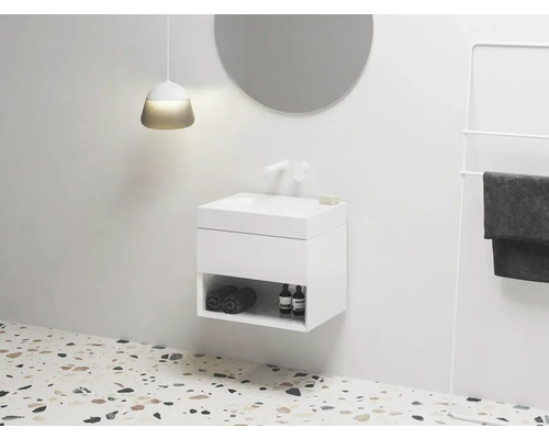 Moderní koupelna s umyvadlovou skříňkou, kulatým zrcadlem a držákem na ručníky