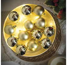 Dekorativní zlaté vánoční koule na talíři s světelným řetězem