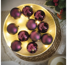 Dekorativní fialové vánoční koule se světelným řetězem na podnosu