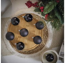 Dekorativní černé vánoční koule na dřevěném talíři