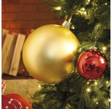 Detailní záběr vánočního stromku se zlatými a červenými ozdobami