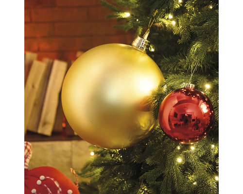 Detailní záběr vánočního stromku se zlatými a červenými ozdobami