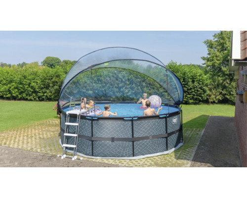Kulatý bazén s krytem a žebříkem na zahradě s hrajícími si dětmi.