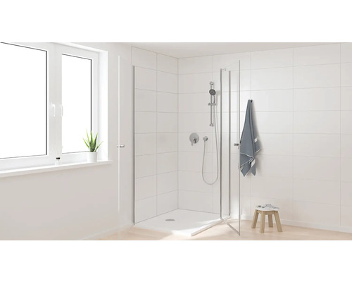 Světlá koupelna se sprchovým koutem, ručníkem a oknem pro přátelské prostředí