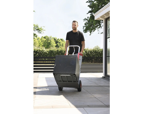 Muž přepravuje krabici s rudlem venku.