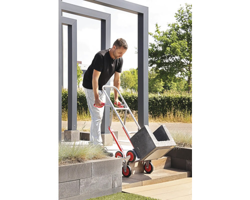 Muž přepravuje květináče pomocí schodišťového vozíku