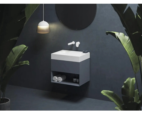 Koupelna s umyvadlovou skříňkou, baterií, kulatým zrcadlem a závěsnou lampou