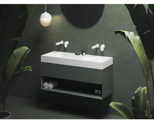 Moderní koupelna s umyvadlovou skříňkou, umyvadlem na desku a kulatým zrcadlem.