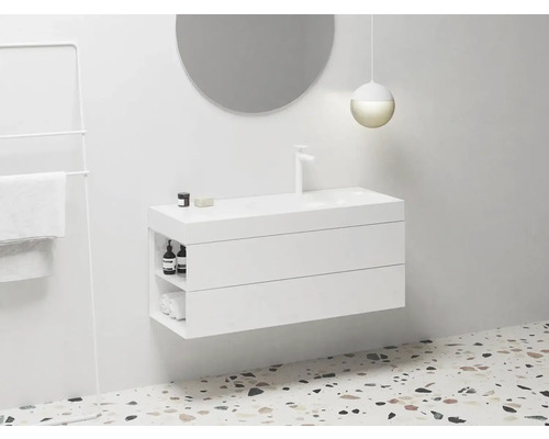 Moderní koupelna s bílou skříňkou pod umyvadlo, kulatým zrcadlem a držákem na ručníky