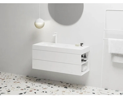 Moderní koupelna s bílou skříňkou pod umyvadlo, kulatým zrcadlem a držákem na ručníky