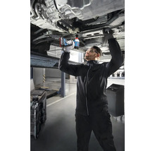 Mechanik používá akumulátorový rázový utahovák k práci na autě, které je na zvedáku.