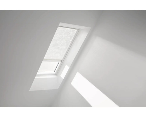 Střešní okno se zavřenou plisovanou žaluzií v jasné místnosti.