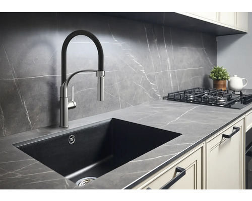 Kuchyňská scéna s dřezem, baterií, varnou deskou a pracovní deskou v moderním designu.