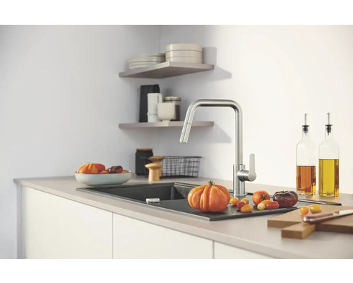 Kuchyňská scéna s kuchyňskou baterií, dřezem a potravinami na pracovní desce.