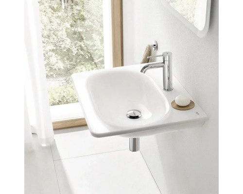 Fotografie umyvadla s baterií, mýdlem a držákem na ručníky v světlé koupelně