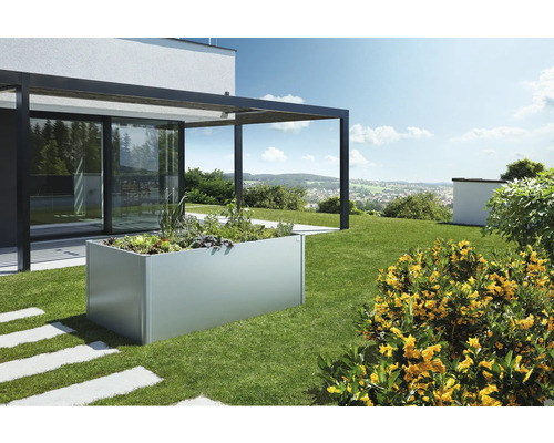 Kovový vyvýšený záhon na zahradě osázený rostlinami