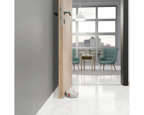 Dveřní zarážka pod dřevěnými dveřmi na mramorové podlaze