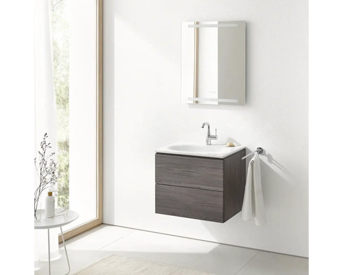 Moderní koupelna s umyvadlovou skříňkou, umyvadlem, osvětleným zrcadlem a držákem na ručníky