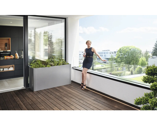 Balkonová scéna s květináčem, ženou a pohledem do kuchyně