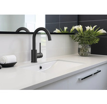 Koupelnové umyvadlo s baterií, ručníkem a vázou s květinami