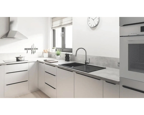 Moderní kuchyně s dřezem, baterií, varnou deskou a odsavačem par.