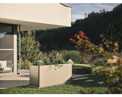 Obdélníkový kovový květináč s rostlinami na zahradě