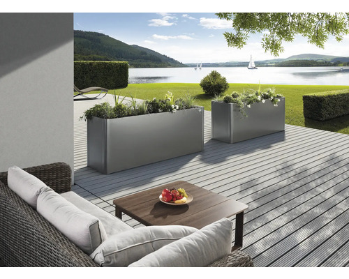 Dva osázené obdélníkové kovové truhlíky na terase s výhledem na jezero.