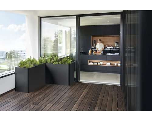 Balkon s bylinkami v truhlících a výhledem do kuchyně