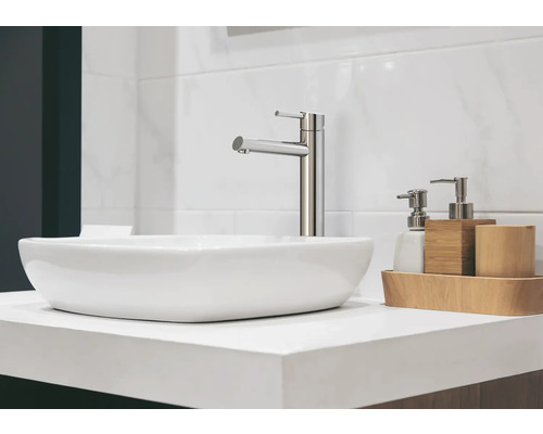 Umyvadlo s vodovodní baterií a dávkovači mýdla na světlém umyvadlovém stolku