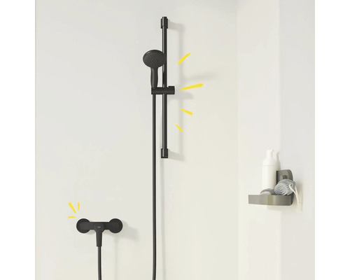 Černá sprchová souprava s tyčí a odkládací plochou v koupelně.