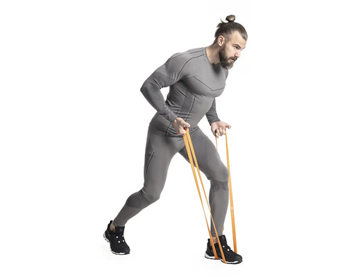 Muž cvičí s odporovou gumou v šedém sportovním oblečení.