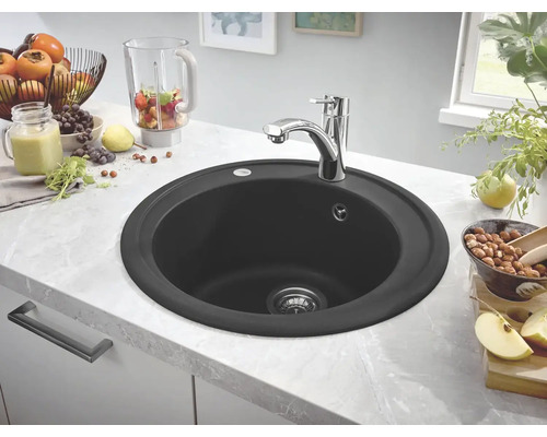 Kulatý černý kuchyňský dřez s vodovodní baterií na kuchyňské lince