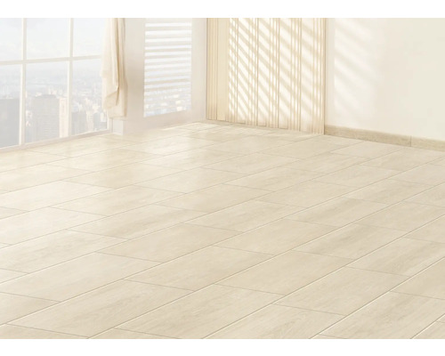 Světlá místnost s položenou dlažbou a oknem