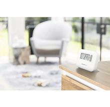 Termostat Honeywell Home na stole v obývacím pokoji.