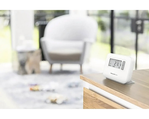 Termostat Honeywell Home na stole v obývacím pokoji.