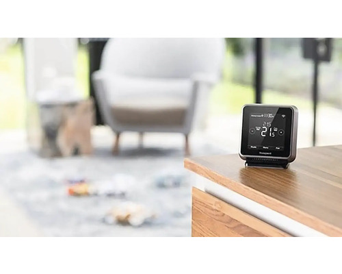 Chytrý termostat Honeywell na dřevěné skříni v obývacím pokoji