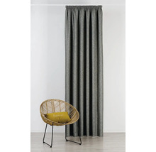 Látkový závěs vedle ratanového křesla s polštářem